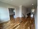 Bright hallway with hardwood flooring, white trim and natural light from open door at 4905 Hidden Pasture Way, Zebulon, NC 27597