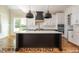 Modern kitchen with white cabinets, black island, and stainless steel appliances at 4905 Hidden Pasture Way, Zebulon, NC 27597