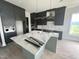 Spacious kitchen with dark cabinets, a large island with quartz countertops, and stainless steel appliances at 4905 Hidden Pasture Way, Zebulon, NC 27597