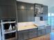 Modern kitchen boasts gray cabinets, stainless steel appliances, and hardwood floors at 4905 Hidden Pasture Way, Zebulon, NC 27597