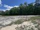 Grassy land area ready for new construction surrounded by lush trees at 4905 Hidden Pasture Way, Zebulon, NC 27597