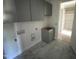 Spacious laundry room with grey cabinets, tile floor and plenty of room for storage. New construction at 4905 Hidden Pasture Way, Zebulon, NC 27597