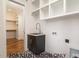 A modern laundry room with stylish tiling, ample storage, and a sink, creating an efficient and pleasant space at 4905 Hidden Pasture Way, Zebulon, NC 27597