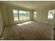 Spacious living room with large windows providing natural light and scenic views, complemented by hardwood floors at 4905 Hidden Pasture Way, Zebulon, NC 27597