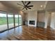 Open living room with fireplace, custom cabinets, ceiling fan, and sliding doors to outdoor living at 4905 Hidden Pasture Way, Zebulon, NC 27597