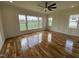 Bright living room featuring hardwood floors, large windows, and ceiling fan at 4905 Hidden Pasture Way, Zebulon, NC 27597