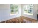 Bright living room featuring hardwood floors, white wainscoting and large windows at 4905 Hidden Pasture Way, Zebulon, NC 27597