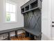 Mudroom featuring dark grey bench, coat hooks, shelves and window at 4905 Hidden Pasture Way, Zebulon, NC 27597