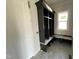 Mudroom with grey tile flooring and built in shelving with a bench seat next to the door at 4905 Hidden Pasture Way, Zebulon, NC 27597