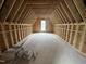 Unfinished attic space featuring exposed wood beams and a window, offering potential for customization at 4905 Hidden Pasture Way, Zebulon, NC 27597