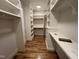 Spacious walk-in closet featuring custom shelving, storage, and hardwood floors at 4905 Hidden Pasture Way, Zebulon, NC 27597