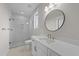 Bathroom with white tiled walls, marble counters, and brass fixtures, featuring a glass-door shower at 4909 Hidden Pasture Way, Zebulon, NC 27597