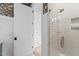 Shower with white tiling and brass fixtures shown through bathroom door at 4909 Hidden Pasture Way, Zebulon, NC 27597