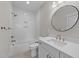 Bathroom with white tiled walls, marble counters, and brass fixtures, featuring a bathtub and shower at 4909 Hidden Pasture Way, Zebulon, NC 27597