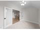 Bedroom with neutral walls, plush carpeting, modern light fixture and a doorway leading to hallway at 4909 Hidden Pasture Way, Zebulon, NC 27597