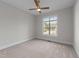 Bedroom with neutral walls, plush carpeting, ceiling fan and a large window overlooking the landscape at 4909 Hidden Pasture Way, Zebulon, NC 27597