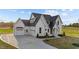 This stunning home boasts a manicured lawn, a three-car garage, and a welcoming covered front porch at 4909 Hidden Pasture Way, Zebulon, NC 27597