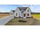 Beautiful home exterior with manicured lawn, elegant entrance, and a three car garage at 4909 Hidden Pasture Way, Zebulon, NC 27597