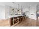 An open kitchen features a large island with seating, stone countertops, and modern appliances at 4909 Hidden Pasture Way, Zebulon, NC 27597
