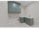 Well-lit laundry room with stylish cabinetry, decorative tile flooring, and modern fixtures at 4909 Hidden Pasture Way, Zebulon, NC 27597