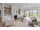 A cozy living room with a fireplace, built-in shelves, and a sliding door to a patio at 4909 Hidden Pasture Way, Zebulon, NC 27597