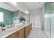 Bright bathroom features double sinks, modern fixtures, and glass shower with teal tiling at 4909 Hidden Pasture Way, Zebulon, NC 27597