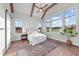 Bright main bedroom features exposed beams, fan, and large windows overlooking the countryside at 4909 Hidden Pasture Way, Zebulon, NC 27597