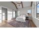 Bright main bedroom features exposed beams, fan, and barn door to the bathroom at 4909 Hidden Pasture Way, Zebulon, NC 27597