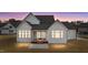 Evening view of rear exterior with screened-in porch and newly seeded lawn at 4909 Hidden Pasture Way, Zebulon, NC 27597