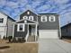 Two-story home with gray siding, brick accents, and a two-car garage at 829 Emmer St, Rolesville, NC 27571