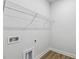 Bright laundry area featuring a wire rack shelf for optimal organization and woodgrain floors at 69 Browning Mill Dr, Wendell, NC 27591