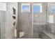 Modern walk-in shower with gray tiling, a bench, and dual shower heads at 69 Browning Mill Dr, Wendell, NC 27591