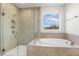 Luxurious bathroom featuring a glass shower, soaking tub, and a view from the window at 55 Browning Mill Dr, Wendell, NC 27591