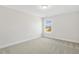 Bedroom with neutral walls and carpet, and window showcasing the view outside at 55 Browning Mill Dr, Wendell, NC 27591