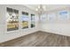 Dining room with large windows, paneled wainscoting, modern chandelier, and wood flooring at 55 Browning Mill Dr, Wendell, NC 27591