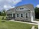 Beautiful home with gray siding, stone accents, covered porch, landscaped yard, and an attached garage at 55 Browning Mill Dr, Wendell, NC 27591