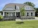 Charming home with gray siding, stone accents, covered porch, manicured lawn, and professional landscaping at 55 Browning Mill Dr, Wendell, NC 27591