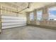 Unfinished garage showcases a white garage door, two windows, concrete floors, and exposed drywall at 55 Browning Mill Dr, Wendell, NC 27591