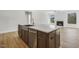 Bright kitchen island featuring stainless steel appliances and quartz countertop, with hardwood flooring and a fireplace in view at 55 Browning Mill Dr, Wendell, NC 27591