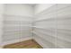 Walk-in pantry featuring white wire shelving on all sides and hardwood floors, providing ample space for storage at 55 Browning Mill Dr, Wendell, NC 27591