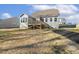 Rear exterior view of the home with a wooden back deck, siding, and trimmed windows in a landscaped yard at 55 Browning Mill Dr, Wendell, NC 27591