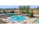 Aerial view of the community pool with a waterslide, tennis courts, and surrounding green spaces at 11548 Helmond Way # 120, Raleigh, NC 27617