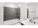 Clean bathroom featuring gray tiled shower/tub, white vanity, and a single sink, creating a sleek and modern space at 11548 Helmond Way # 120, Raleigh, NC 27617