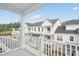 Exterior view from a balcony of white townhouse-style homes with black roofs under a clear sky at 11548 Helmond Way # 120, Raleigh, NC 27617