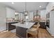 Modern kitchen featuring an island with a white countertop and dark-stained cabinetry and stainless steel range hood at 148 Hook Dr # 7, Fuquay Varina, NC 27526