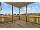 Wooden back porch with a natural wooden railing and view of the field at 65 Diamond Creek Dr, Zebulon, NC 27597