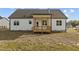 Backyard view of the home with a wooden porch and a partially sodded yard at 65 Diamond Creek Dr, Zebulon, NC 27597