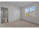 Spare bedroom boasts neutral walls, carpet, and a large window at 65 Diamond Creek Dr, Zebulon, NC 27597