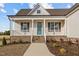 Charming single-story home featuring a welcoming front porch, manicured landscaping, and a stylish blue front door at 65 Diamond Creek Dr, Zebulon, NC 27597