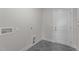 Tile laundry room with gray flooring, white walls, and utility hook-ups near the back door at 65 Diamond Creek Dr, Zebulon, NC 27597